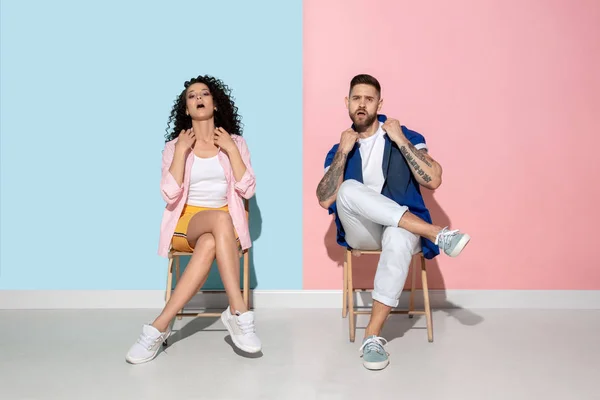 Joven hombre y mujer emocional sobre fondo rosa y azul — Foto de Stock