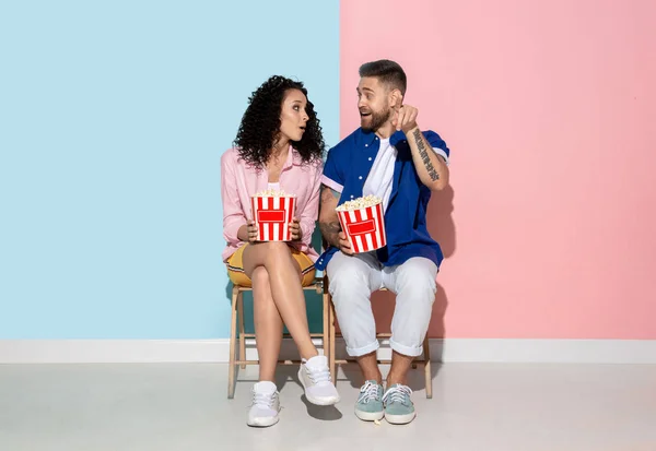 Jonge emotionele man en vrouw op roze en blauwe achtergrond — Stockfoto