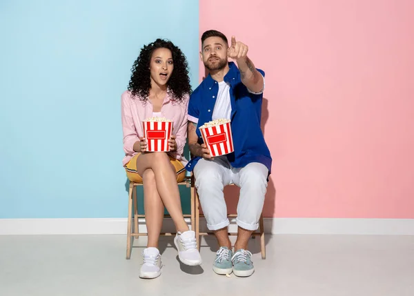 Jonge emotionele man en vrouw op roze en blauwe achtergrond — Stockfoto