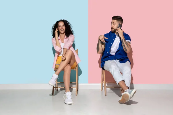 Joven hombre y mujer emocional sobre fondo rosa y azul — Foto de Stock