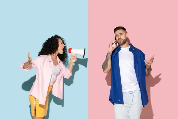 Joven hombre y mujer emocional sobre fondo rosa y azul —  Fotos de Stock