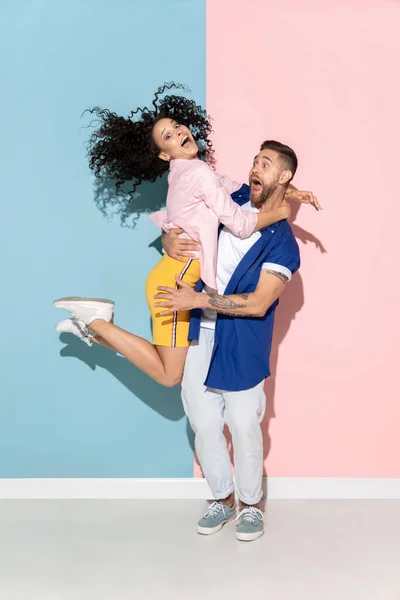 Jovem homem emocional e mulher no fundo rosa e azul — Fotografia de Stock