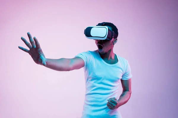 Jovens homens afro-americanos usando óculos VR em luz de néon — Fotografia de Stock