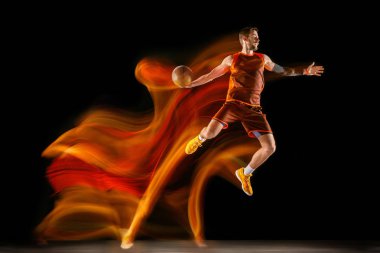 Karışık ışıkta karanlık arka plana karşı genç kafkas basketbolcu