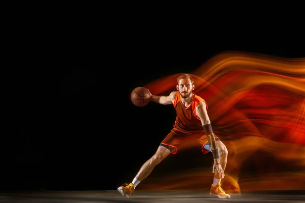 혼합 된 빛에 어두운 배경에 대한 젊은 백인 농구 선수 — 스톡 사진