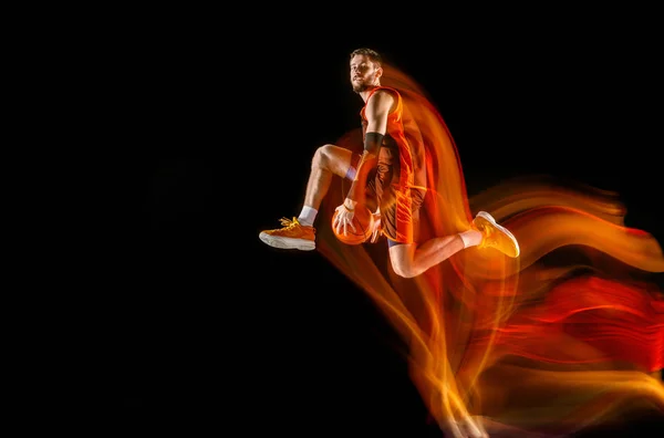 年轻的白人篮球运动员在混合光的黑暗背景 — 图库照片