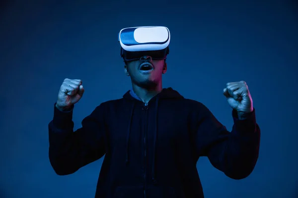 Young african-american mans using VR-glasses in neon light — Stock Photo, Image