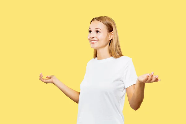 Caucasian young womans half-length portrait on yellow background