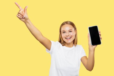 Beyaz genç kadınlar sarı arka plan üzerinde yarım uzunlukta portre