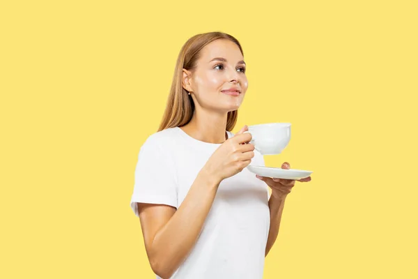 Caucasian young womans half-length portrait on yellow background