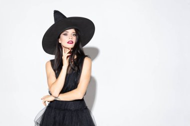 Şapka lı genç kadın ve beyaz arka planda cadı gibi giyin