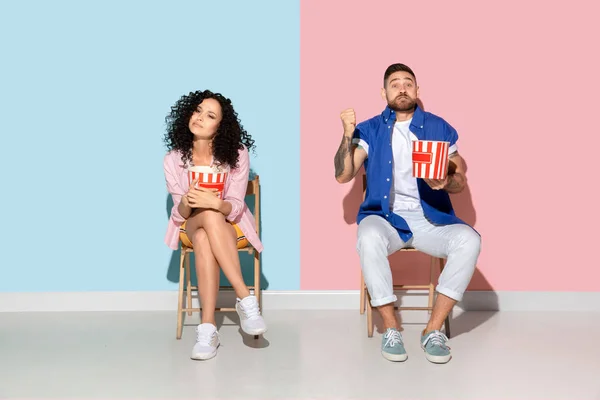 Joven hombre y mujer emocional sobre fondo rosa y azul — Foto de Stock