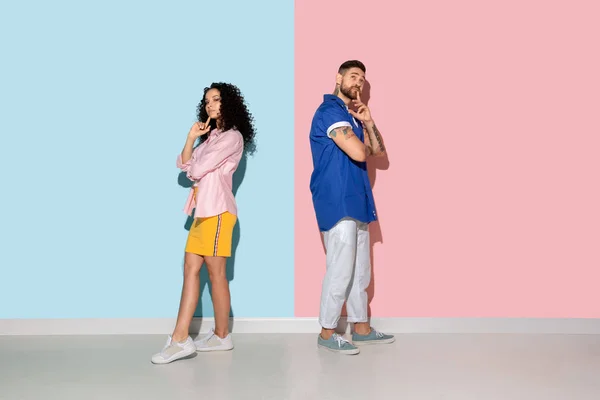 Pemuda emosional pria dan wanita dengan latar belakang merah muda dan biru — Stok Foto