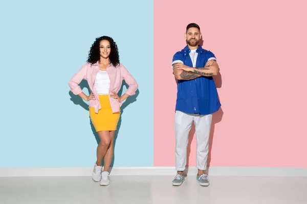 Joven hombre y mujer emocional sobre fondo rosa y azul — Foto de Stock