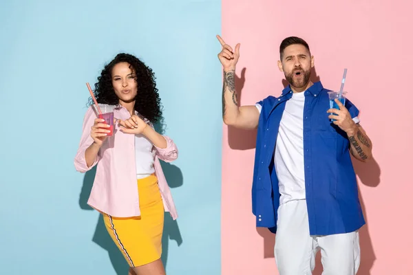 Joven hombre y mujer emocional sobre fondo rosa y azul — Foto de Stock