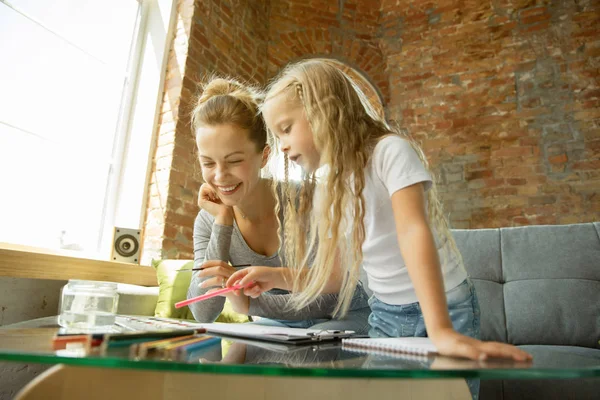 Maestra y niña, o mamá e hija. Concepto de educación en el hogar —  Fotos de Stock