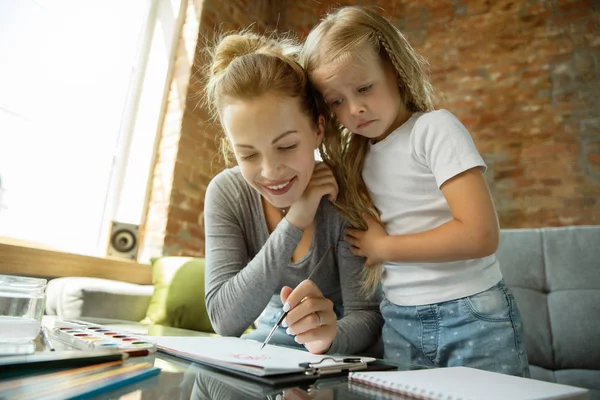 Maestra y niña, o mamá e hija. Concepto de educación en el hogar — Foto de Stock