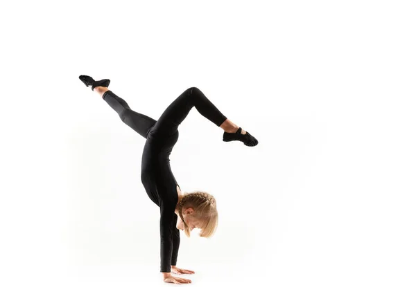 Маленькая гимнастка, практикующая на белом фоне — стоковое фото