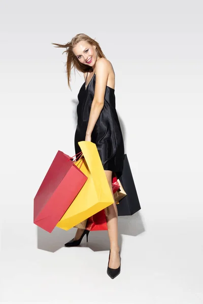 Young woman in dress shopping on white background — Stock Photo, Image