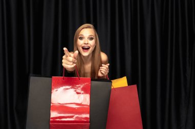 Siyah arka plan üzerinde elbise alışveriş genç kadın