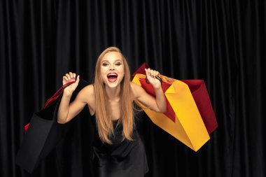 Siyah arka plan üzerinde elbise alışveriş genç kadın