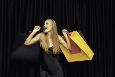 Siyah arka plan üzerinde elbise alışveriş genç kadın