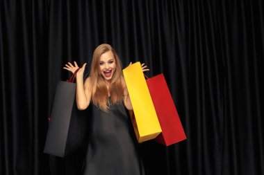 Siyah arka plan üzerinde elbise alışveriş genç kadın