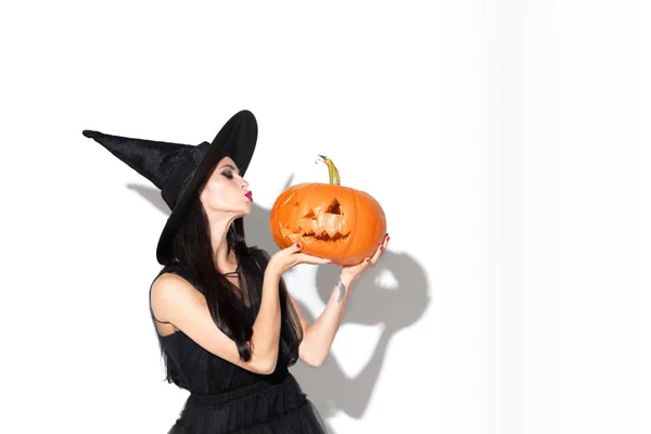 Young woman in hat and dress as a witch on white background — Stock Photo, Image