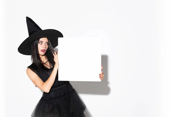 Mujer joven con sombrero y vestido de bruja sobre fondo blanco —  Fotos de Stock