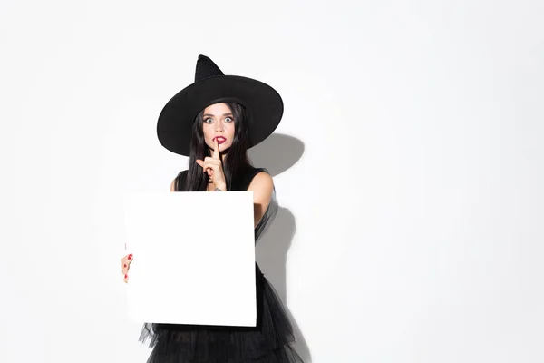 Mujer joven con sombrero y vestido de bruja sobre fondo blanco —  Fotos de Stock
