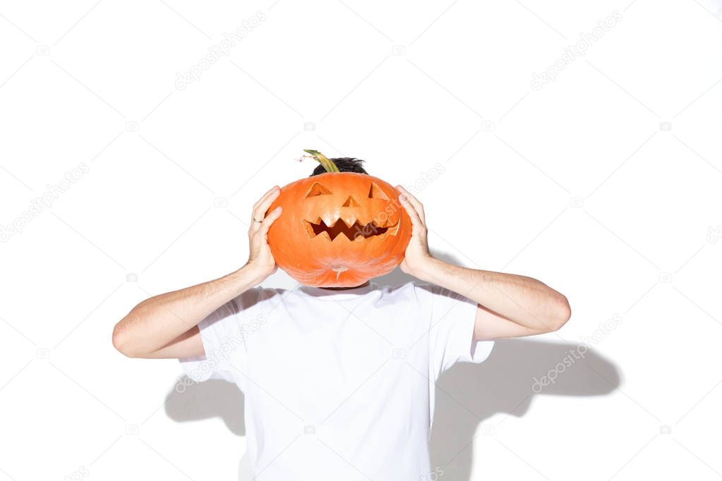 Young man holding pumpking on white background