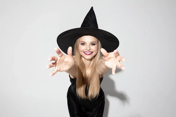 Young woman in hat as a witch on white background — Stock Photo, Image