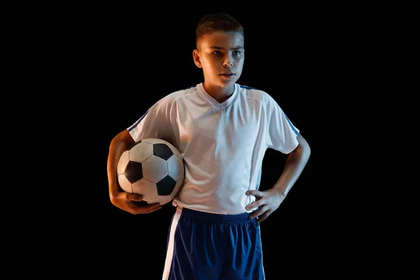 Νεαρό αγόρι ως ποδοσφαιριστής ή ποδοσφαιριστής σε σκοτεινό φόντο στούντιο — Φωτογραφία Αρχείου
