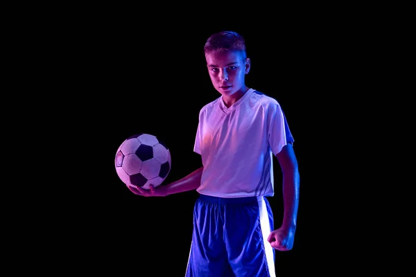 Young boy as a soccer or football player on dark studio background — Stock Photo, Image