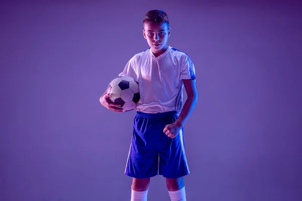 Giovane ragazzo come un giocatore di calcio o di calcio su sfondo scuro studio — Foto Stock