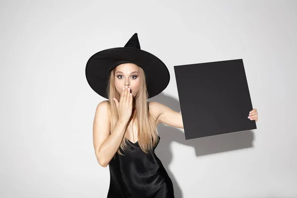 Fiatal nő kalapban, mint a boszorkány, fehér alapon — Stock Fotó