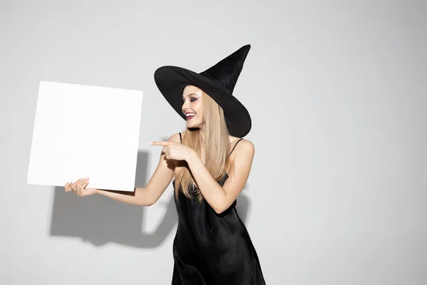 Mujer joven con sombrero como bruja sobre fondo blanco — Foto de Stock