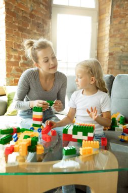 Öğretmen ve küçük kız, ya da anne ve kız. Evde eğitim konsepti