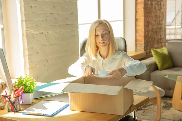 Une jeune femme d'affaires déménageant au bureau, obtenant un nouveau lieu de travail — Photo