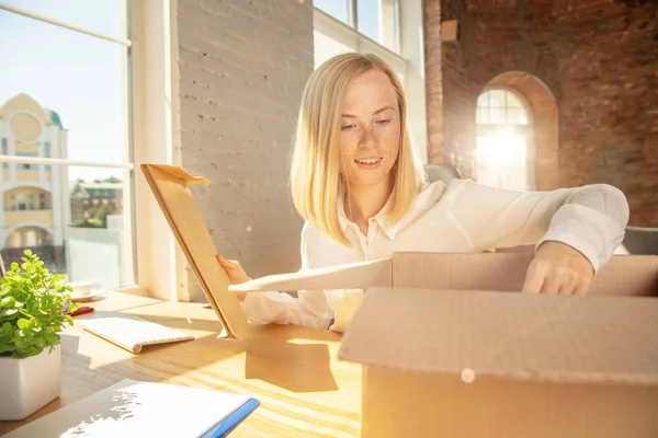 Una joven empresaria que se muda a la oficina, consiguiendo un nuevo lugar de trabajo — Foto de Stock