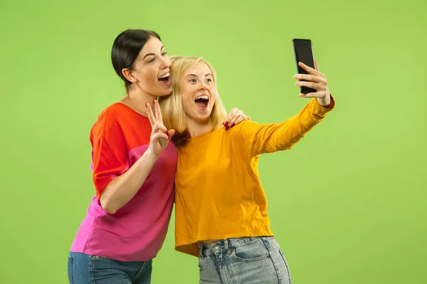 Portrait of pretty girls isolated on green studio background — Stock Photo, Image