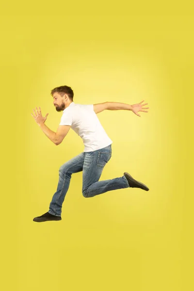 Volledige lengte portret van gelukkig springen man op gele achtergrond — Stockfoto