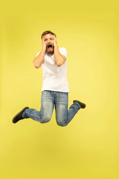 Potret panjang lengkap pria melompat bahagia di latar belakang kuning — Stok Foto