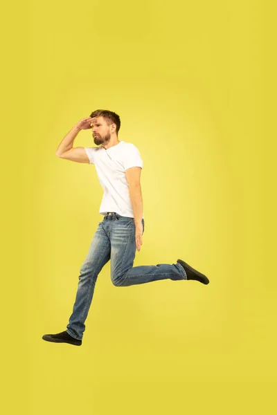 Portrait complet de l'homme sautant heureux sur fond jaune — Photo
