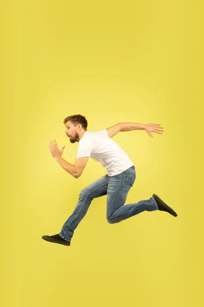 Retrato de comprimento total do homem de salto feliz no fundo amarelo — Fotografia de Stock