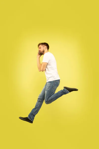 Volledige lengte portret van gelukkig springen man op gele achtergrond — Stockfoto