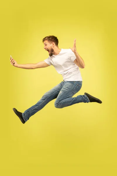 Volledige lengte portret van gelukkig springen man op gele achtergrond — Stockfoto