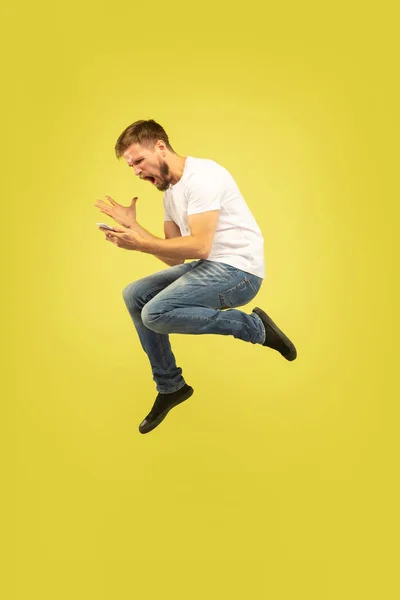 노란색 배경에 행복 점프 남자의 전체 길이 초상화 — 스톡 사진