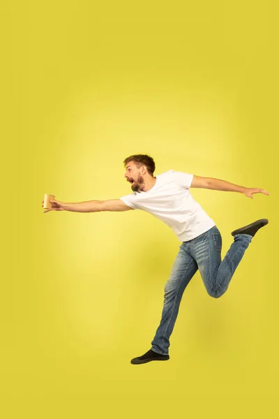 Volledige lengte portret van gelukkig springen man op gele achtergrond — Stockfoto