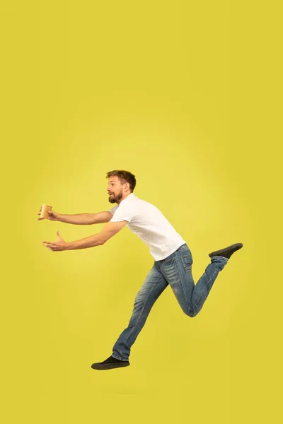 黄色の背景に幸せなジャンプ男の完全な長さの肖像画 — ストック写真